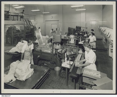 1950 Packing butter at SA Farmers' Co-Op Union Ltd. Dairy Produce Department, Mile End Blocks of butter are fed to a vacuum blender and then moulded and wrapped for distribution to stores.