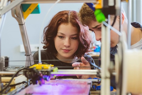 Young people looking at 3D printer- iStock image (1).jpg